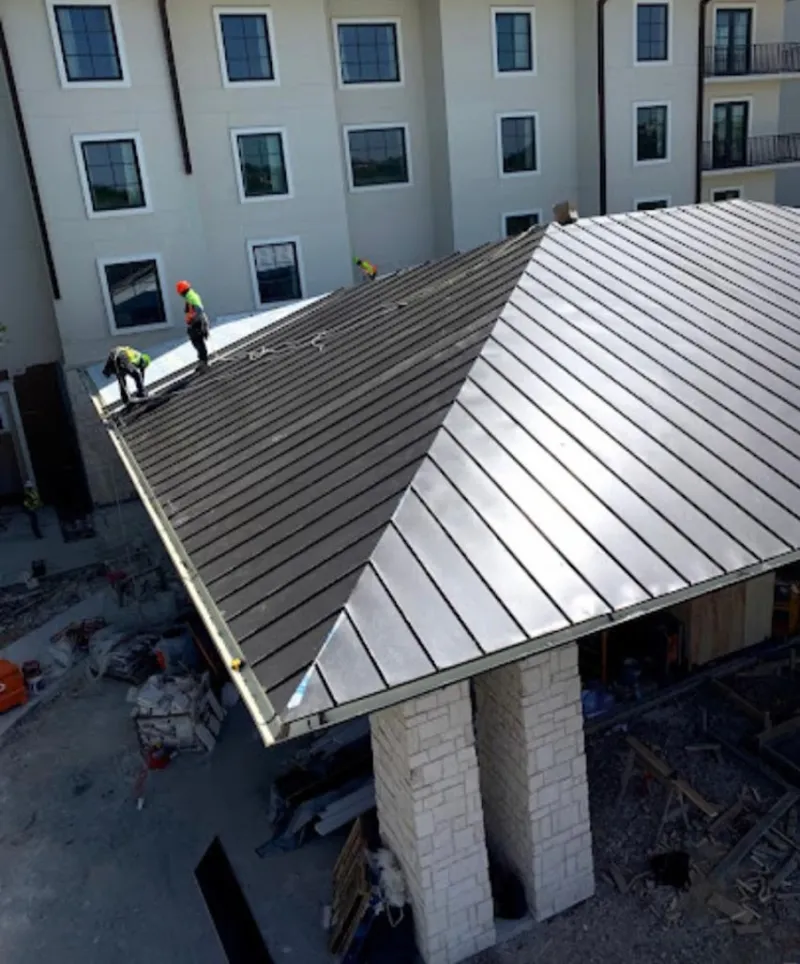 Crew installing standing seam metal roof panels on a commercial project in Stuarts Draft